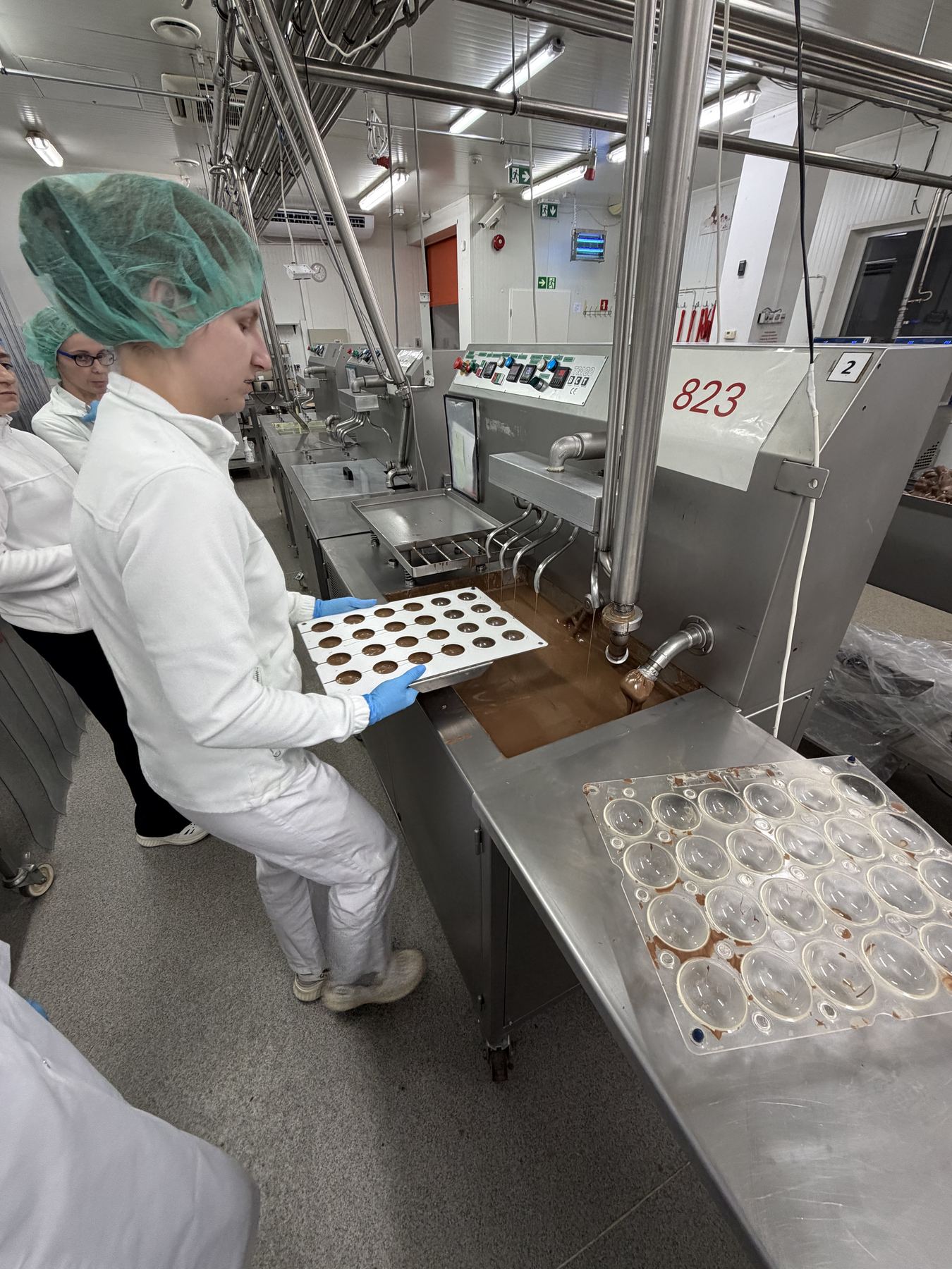 Een mal wordt gevuld met chocolade.
